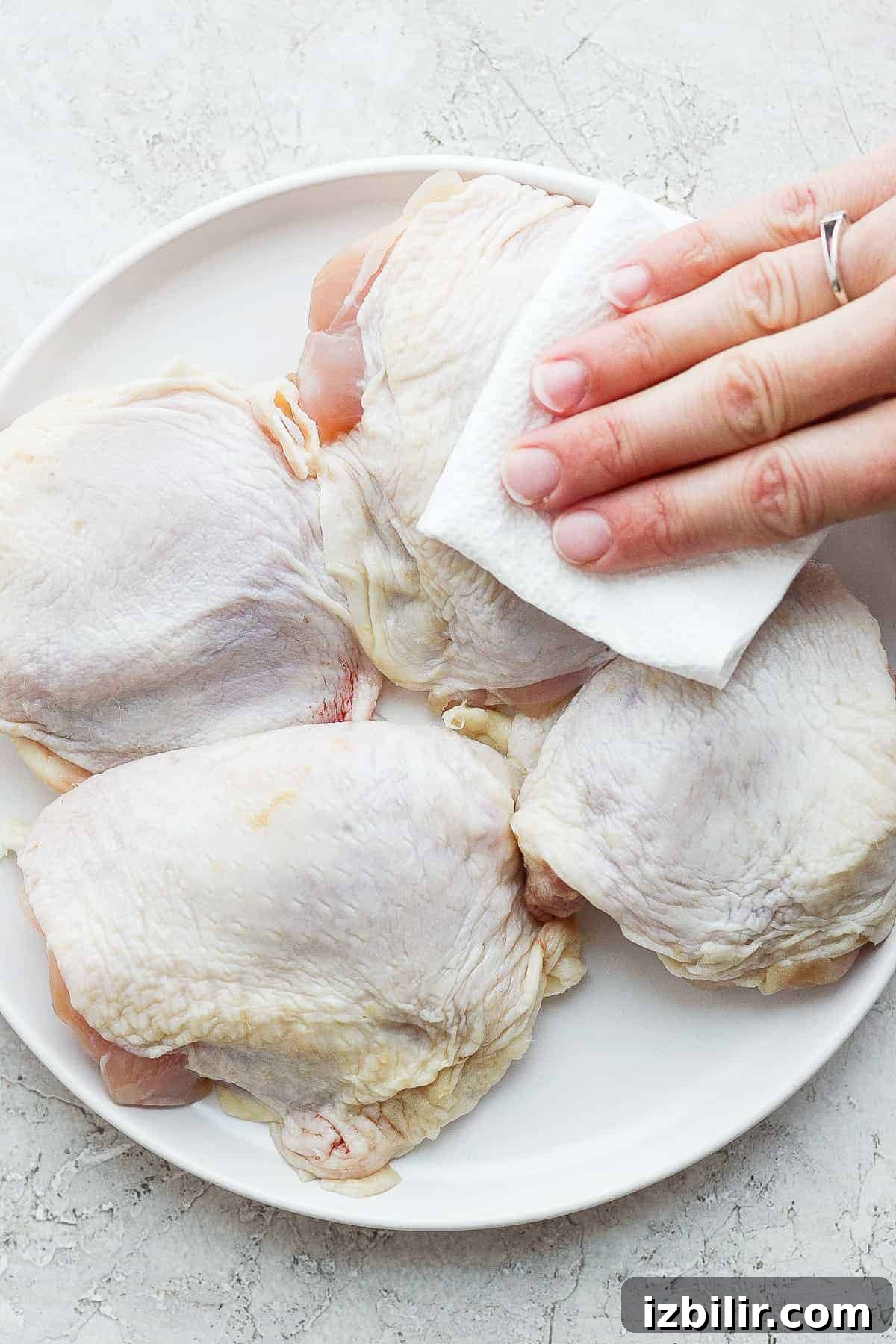 patting chicken thighs with paper towel