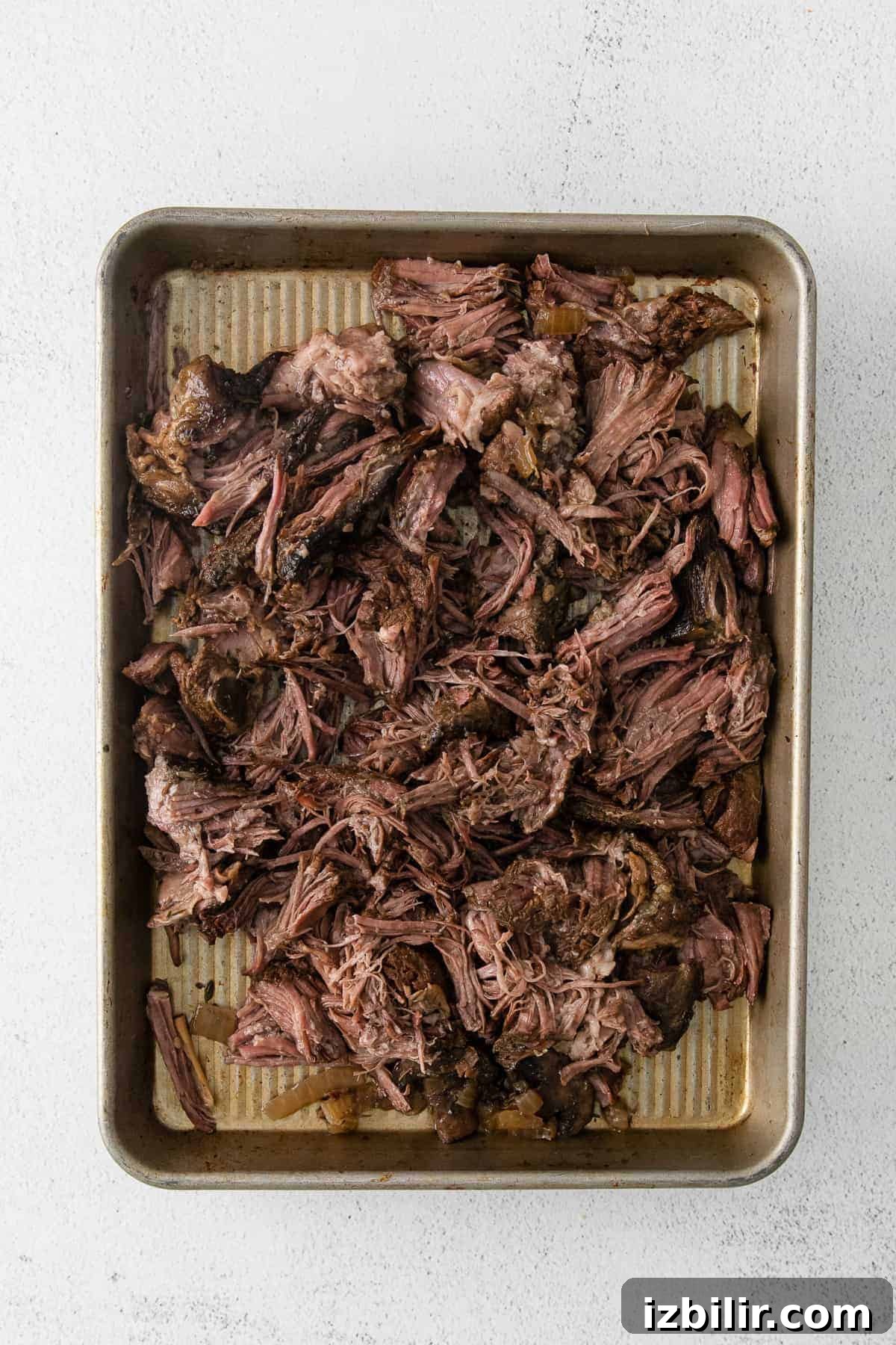Shredded beef ready for the sauce shredded beef on a baking sheet