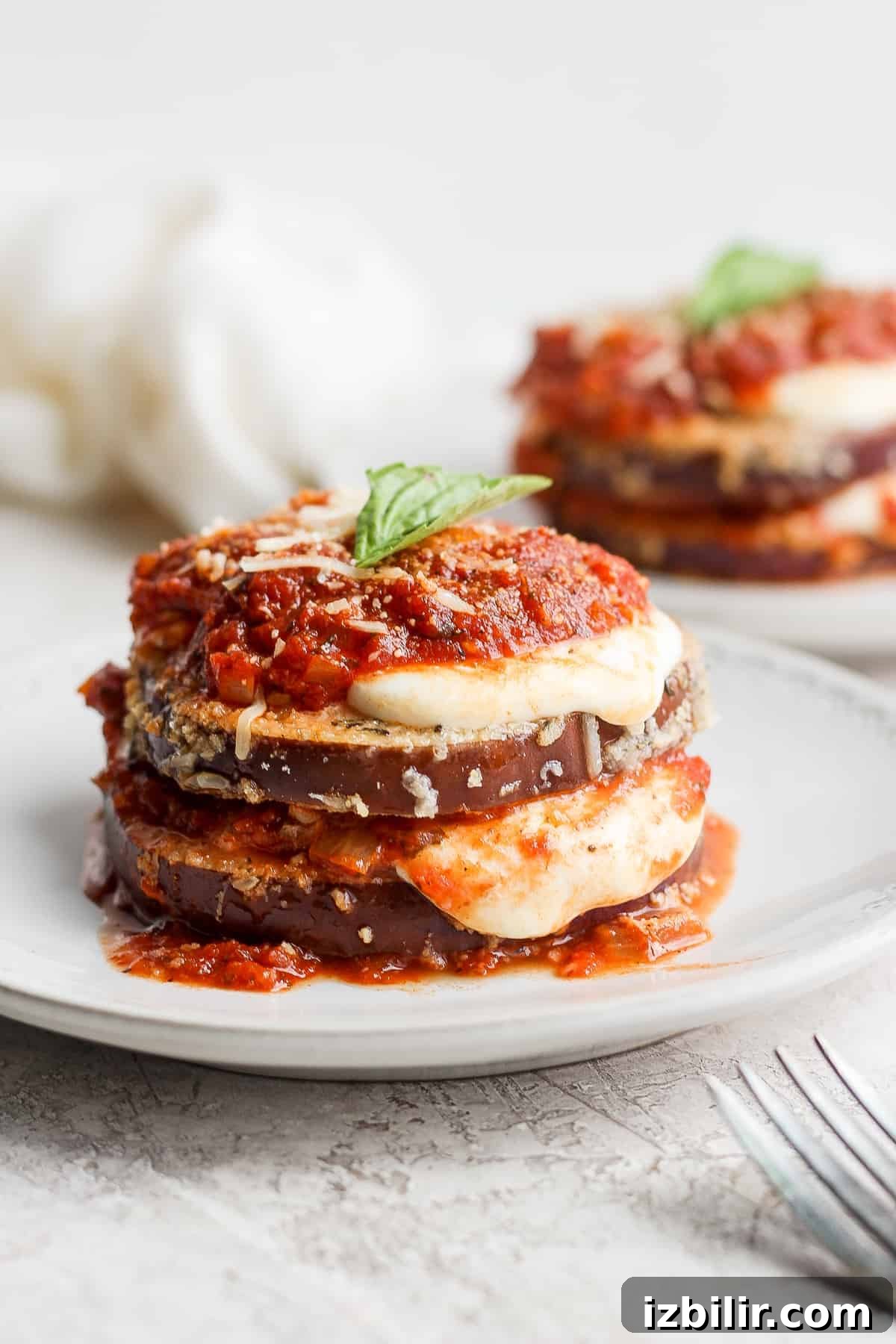 Crispy Baked Eggplant Parmesan Recipe 2 Eggplant parmesan plated and topped with fresh basil.