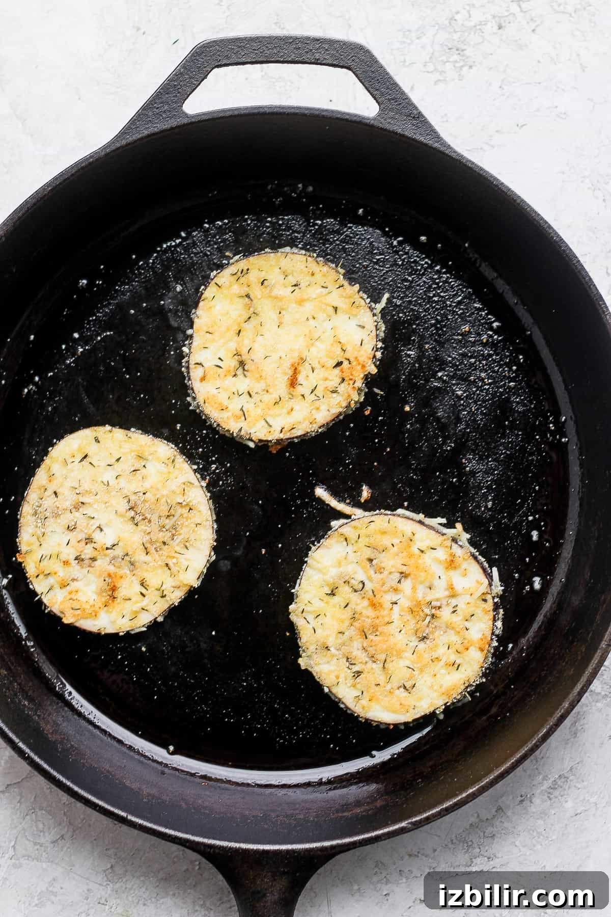 Crispy Baked Eggplant Parmesan Recipe 7 Browning eggplant rounds in a skillet pan.