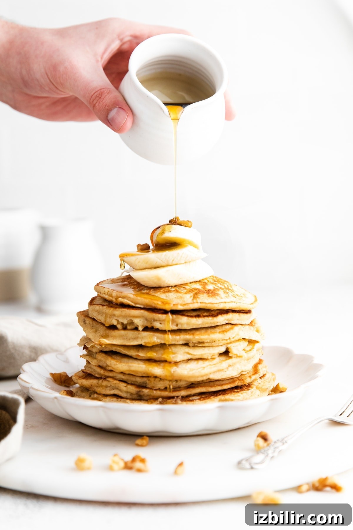 pouring syrup onto banana pancake recipe