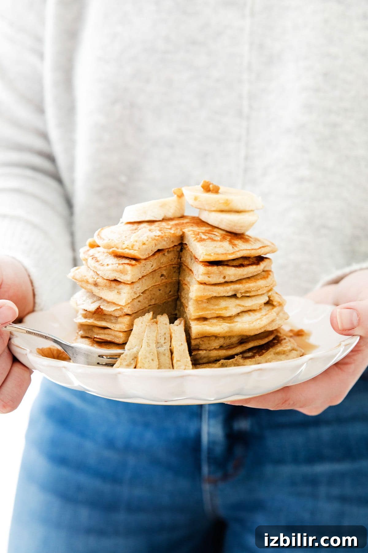 holding a plate of easy banana pancakes