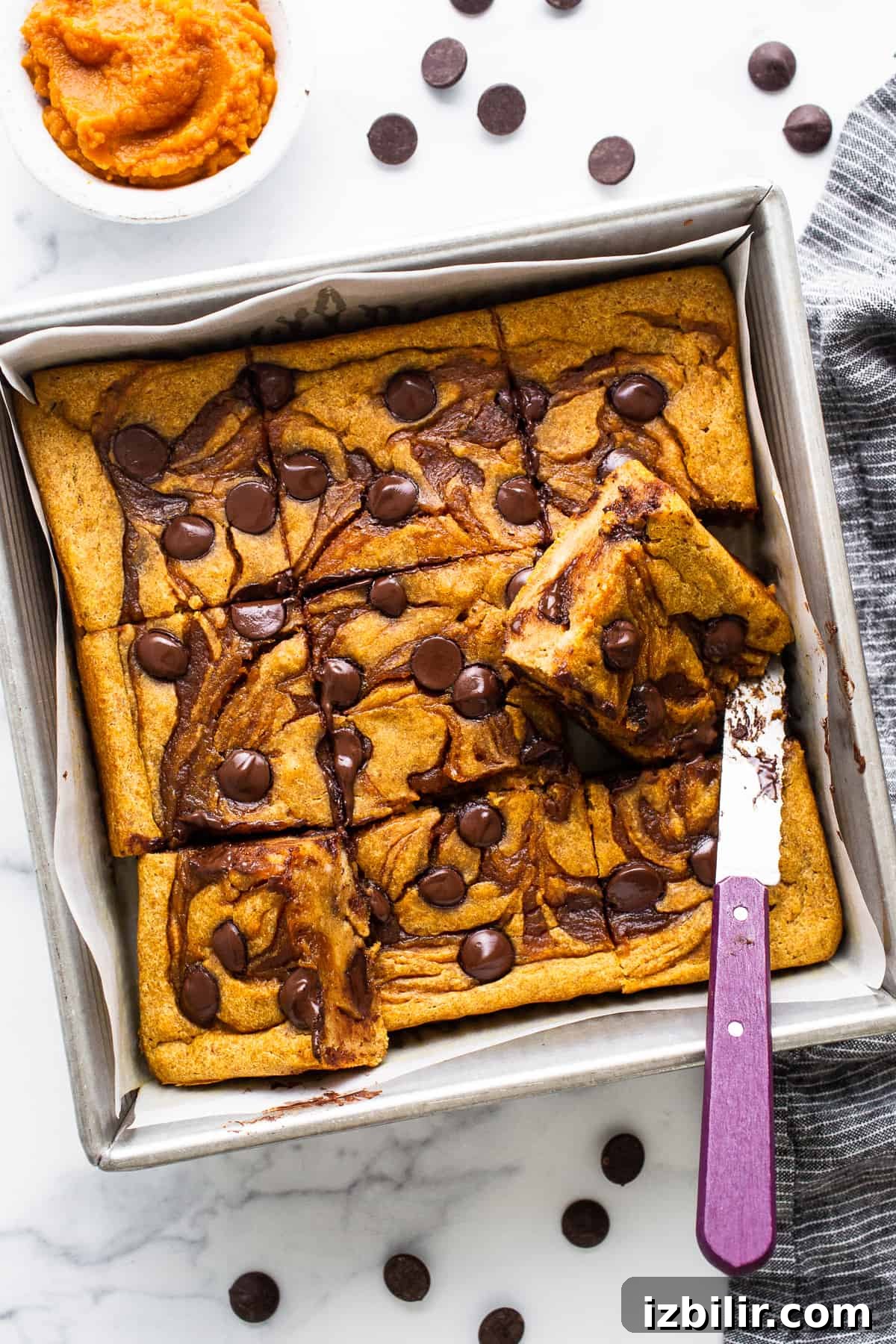Brown Sugar Swirl Pumpkin Breakfast Cake Recipe 2 Pumpkin chocolate chip bars in a baking pan with a knife.