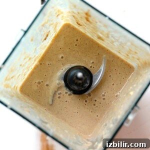 Creamy Apple Smoothie Bowl Recipe with Cinnamon 2 A brown liquid in a blender resembling an apple pie smoothie.