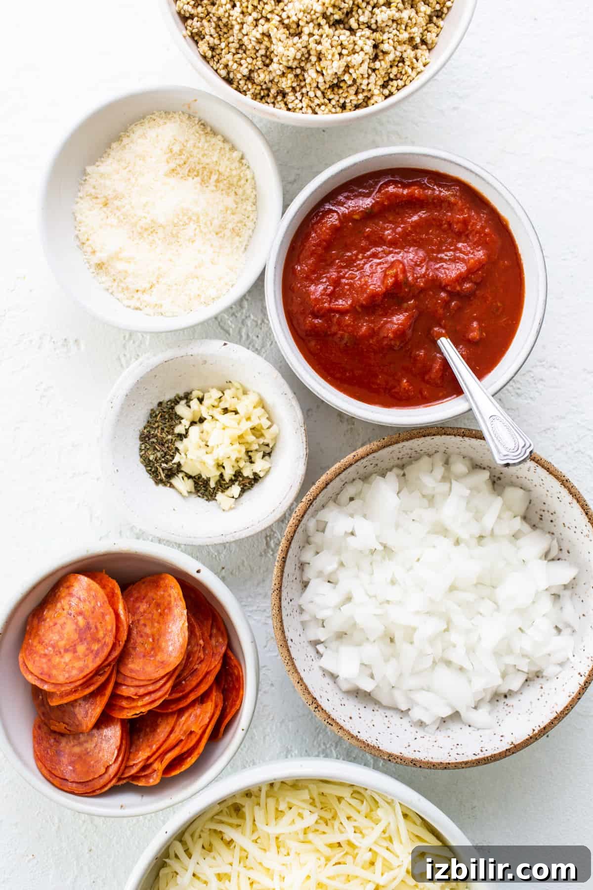 A bowl of ingredients for a pepperoni pizza.