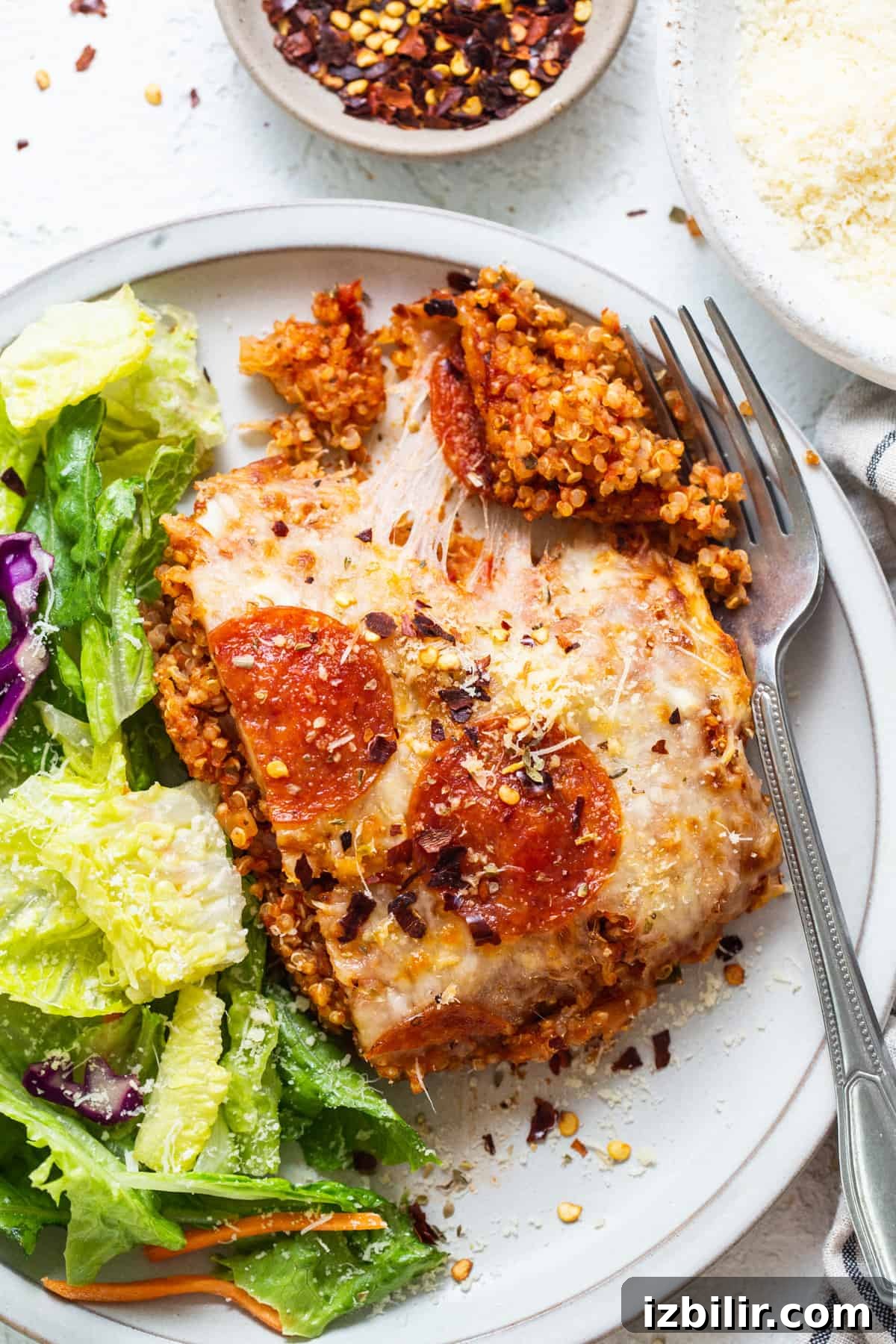 A plate with a pizza and salad on it.