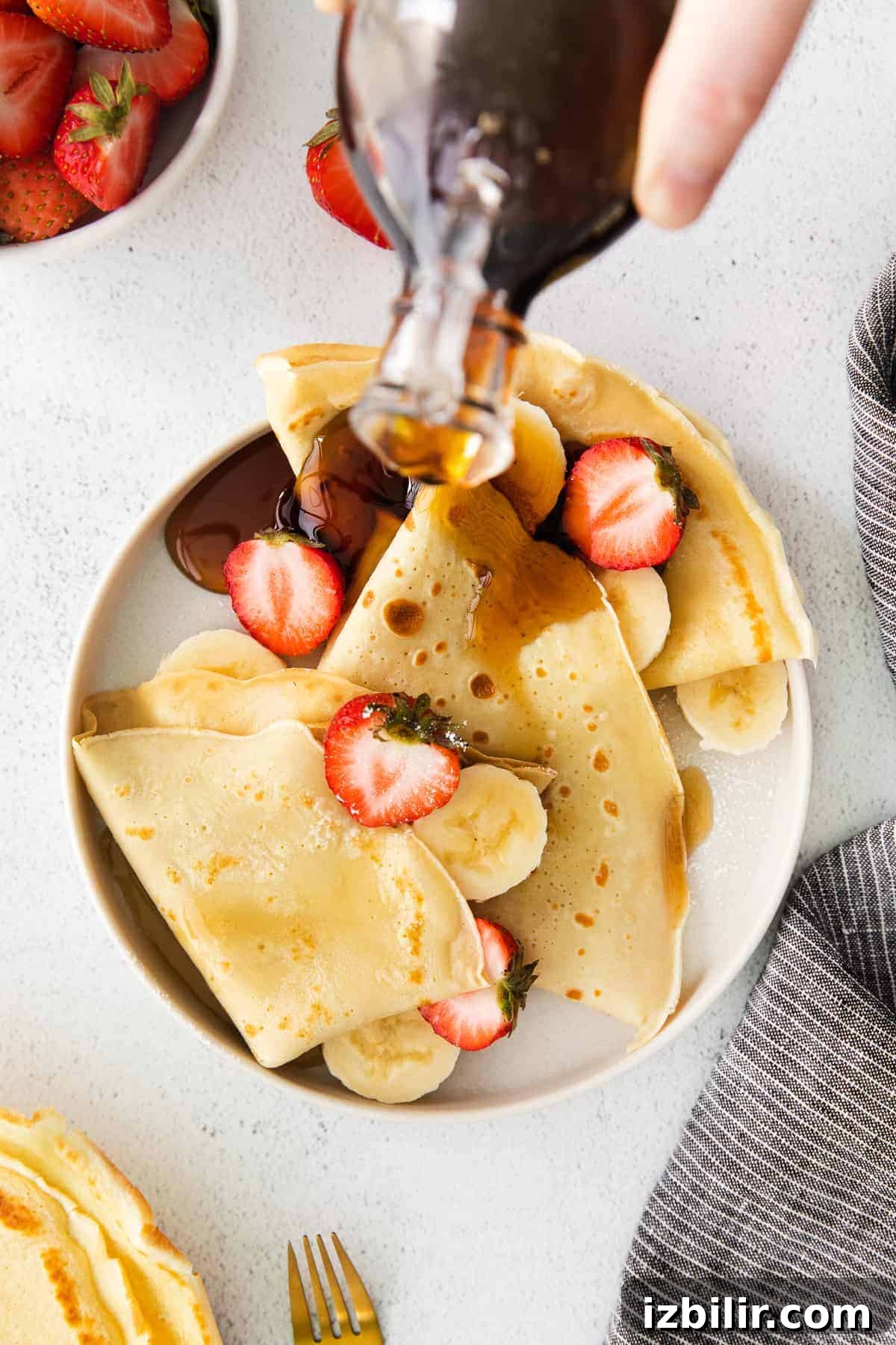 Drizzling maple syrup over crepes.