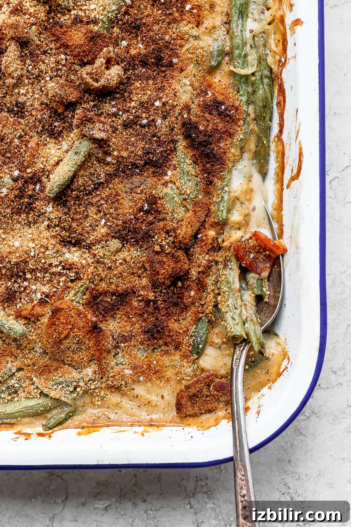 green bean casserole with bacon on a spoon