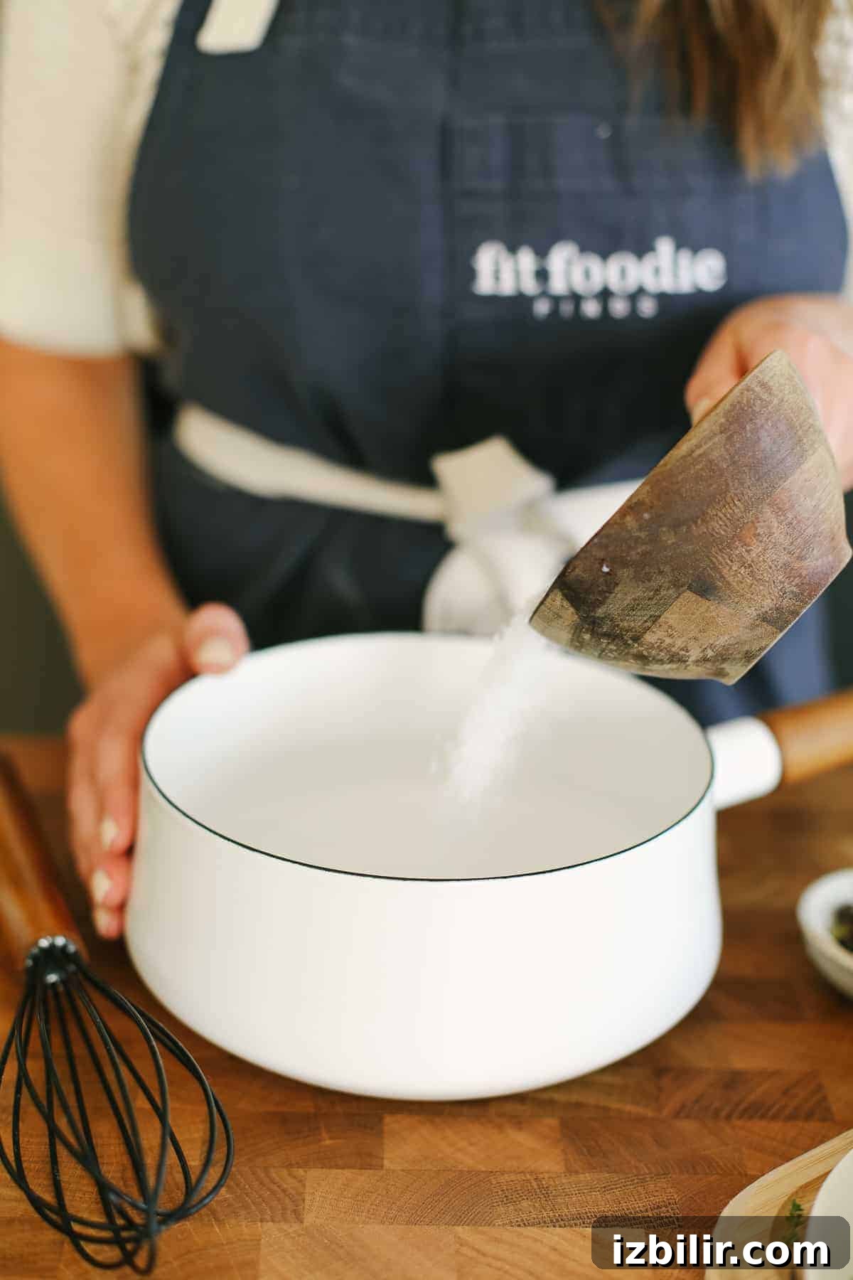 Pouring salt into a small saucepan with water.