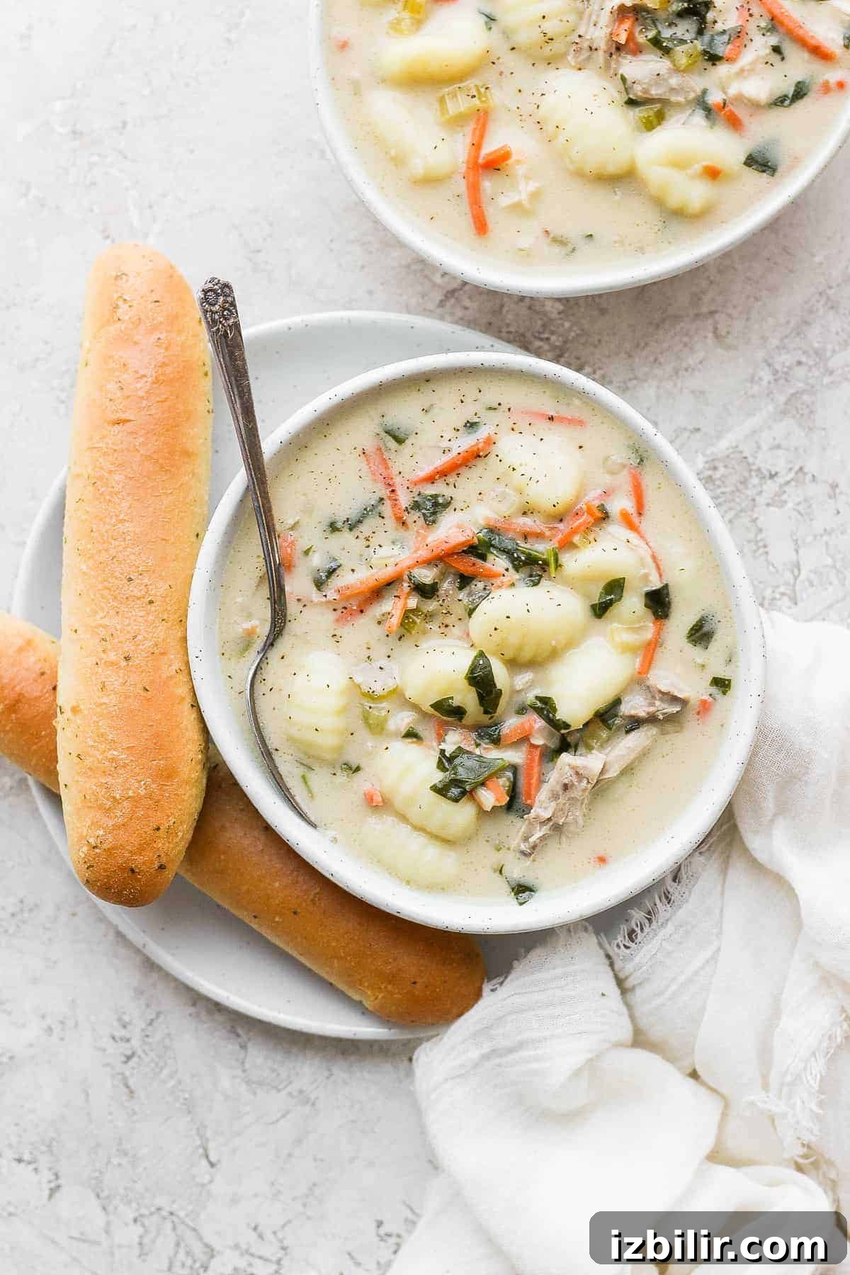 Olive Garden Chicken Gnocchi Soup Olive Garden chicken gnocchi soup in a bowl next to a breadstick