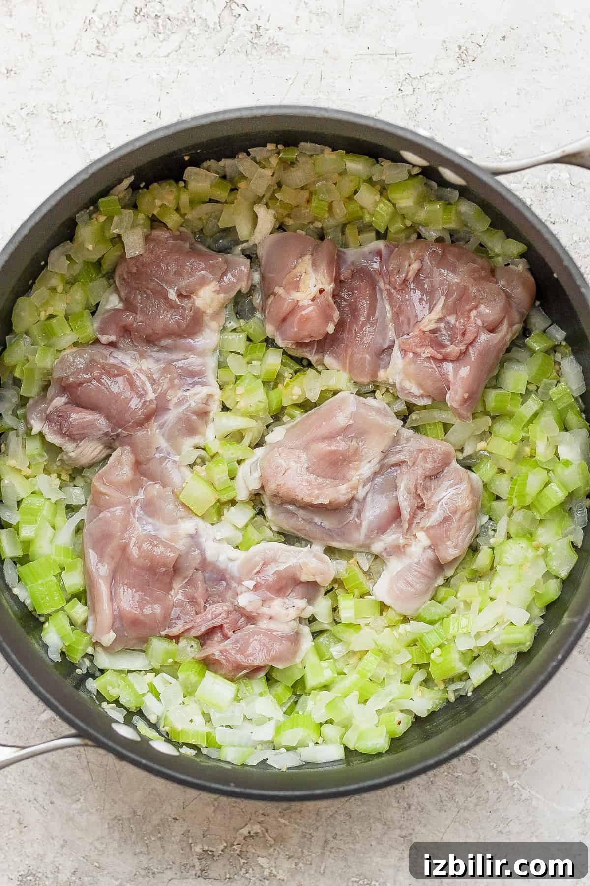 Sauteed onion, celery and chicken Sauteed celery and onions in a dutch oven with chicken thighs