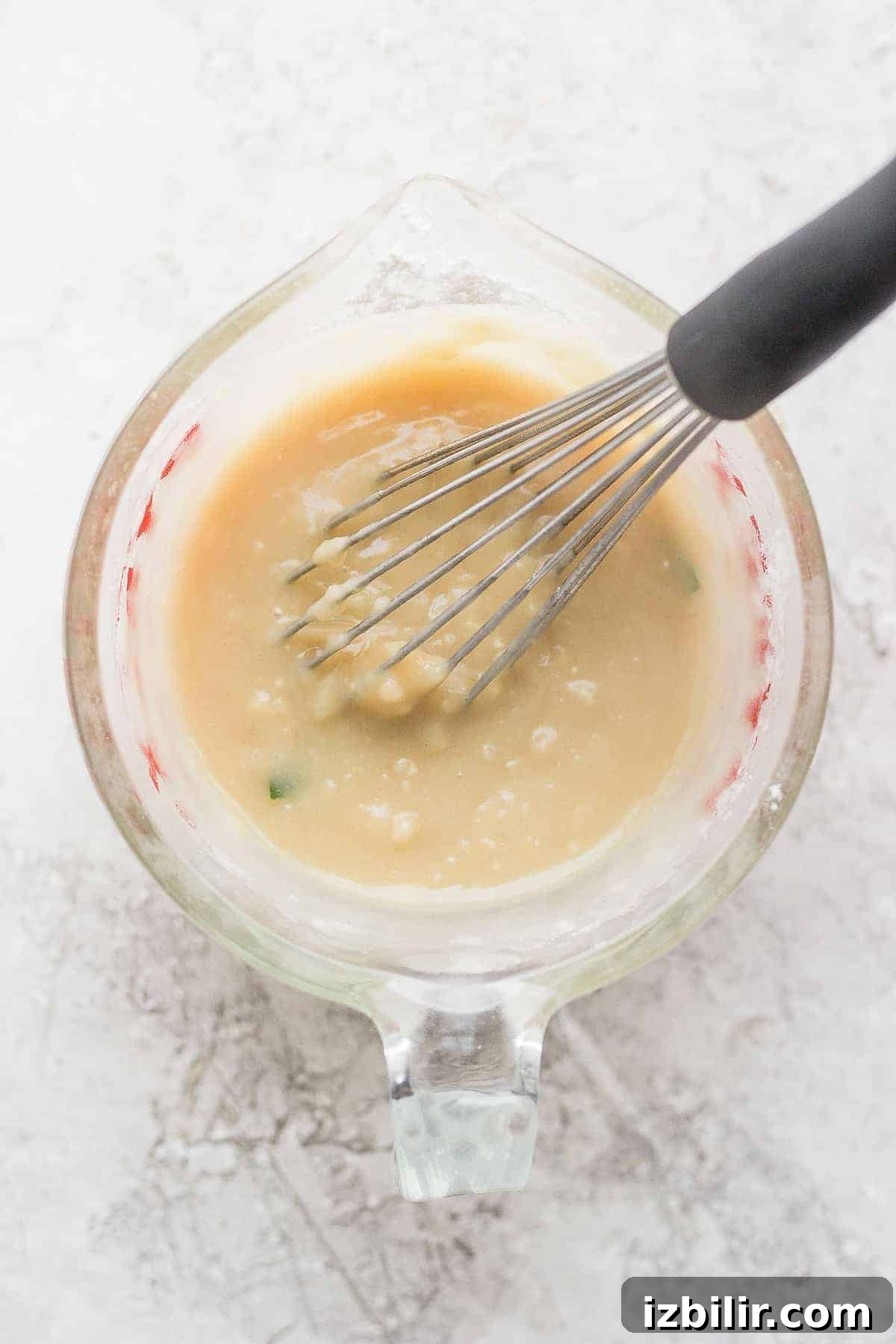 Make a slurry with flour and broth A slurry in a bowl being whisked together