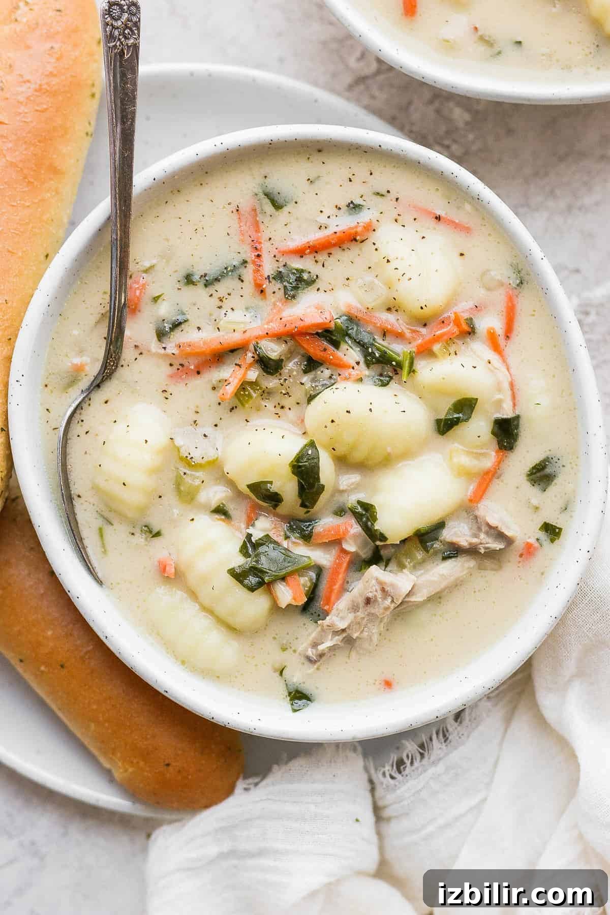 Bowl of chicken gnocchi soup Olive Garden chicken gnocchi soup in a bowl with a spoon