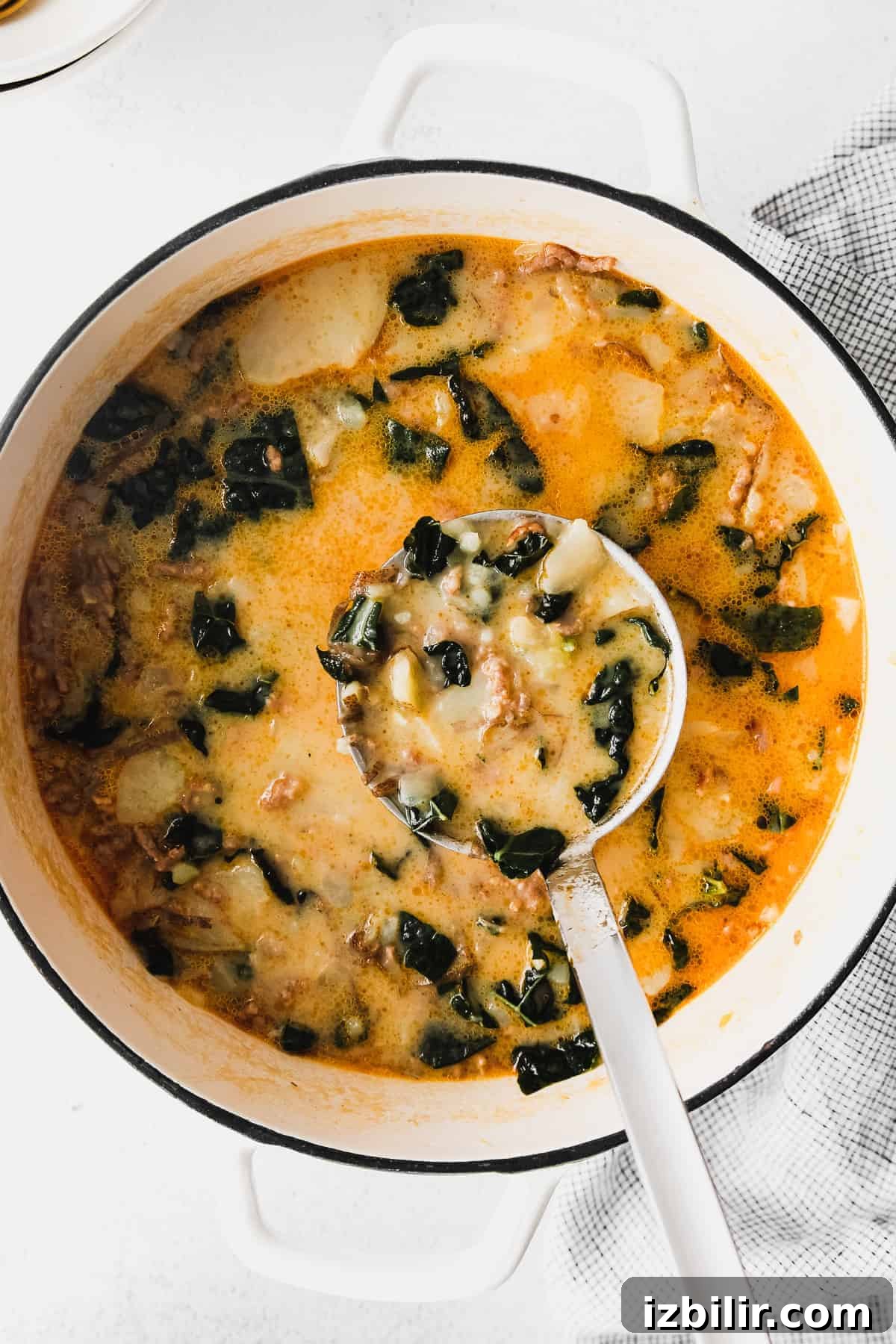 zuppa toscana soup in a stock pot with a ladle full of soup