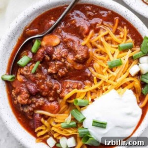 Slow cooker chili with sour cream and green onions.