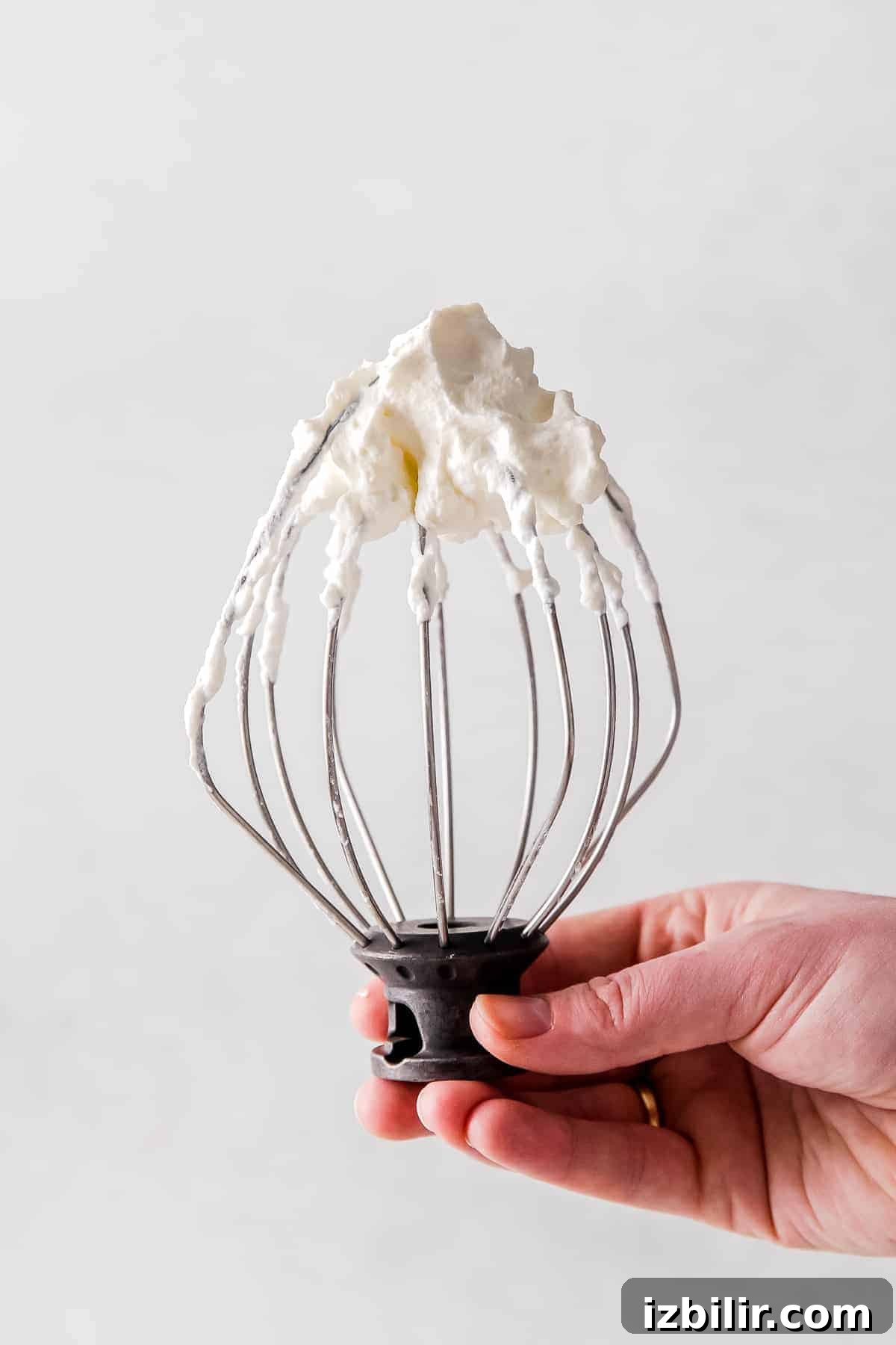 Whipped cream on a whisk attachment.
