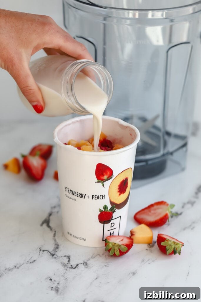 Preparing a Daily Harvest smoothie milk being poured in a smoothie cup before being put in a blender
