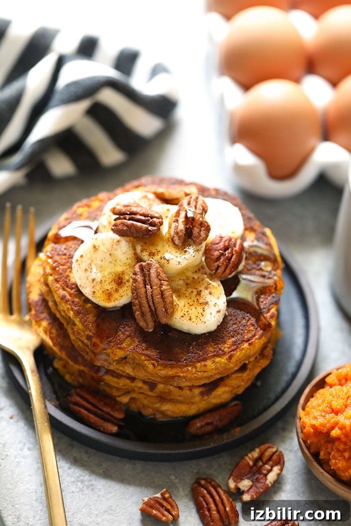 Start your day off right with these grain-free, pumpkin-packed, and oh so scrumptious Paleo Pumpkin Pancakes. Paleo pumpkin pancakes on a plate.