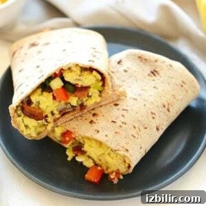 A breakfast burrito on a plate.