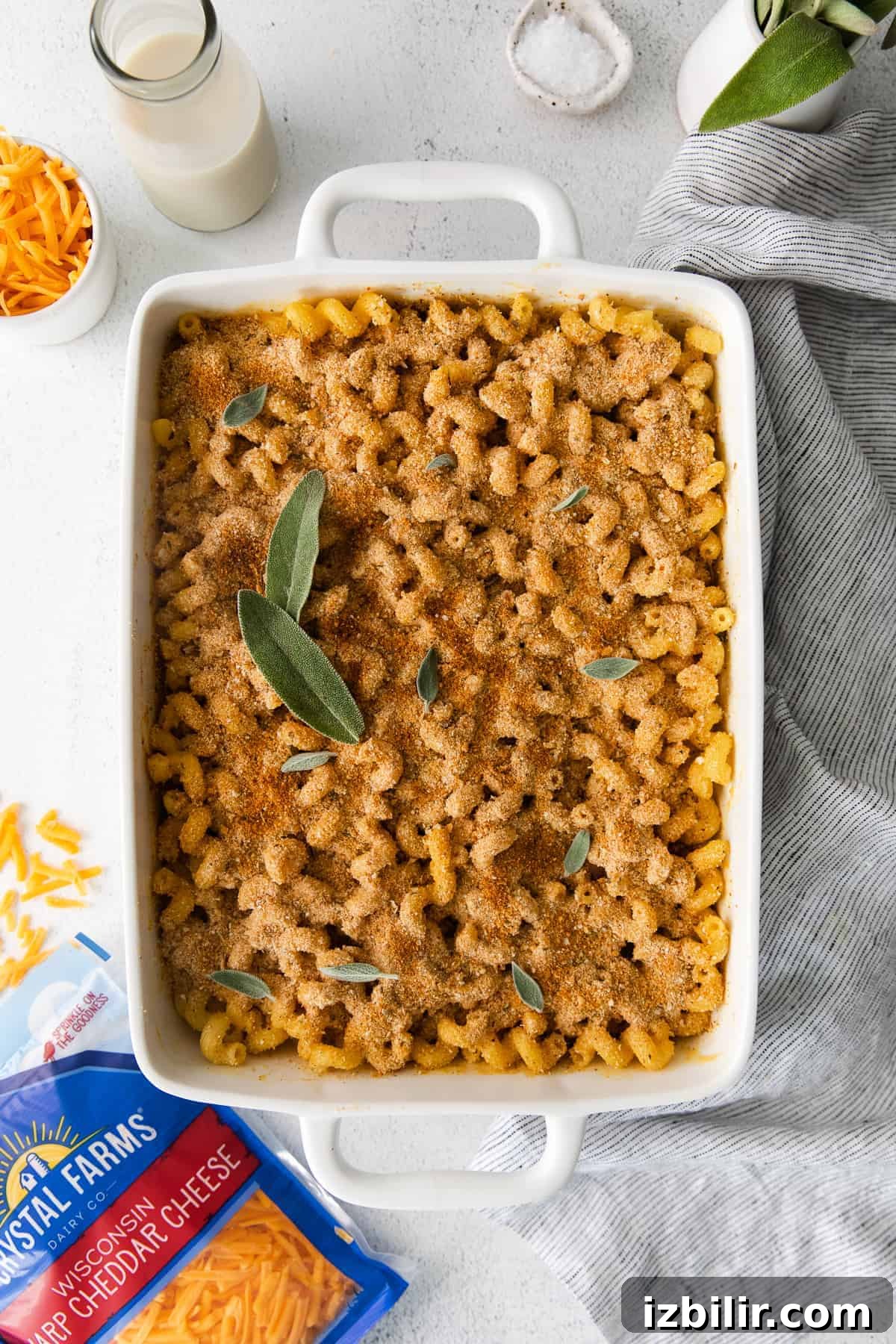 Butternut squash mac and cheese in a casserole dish topped with fresh sage