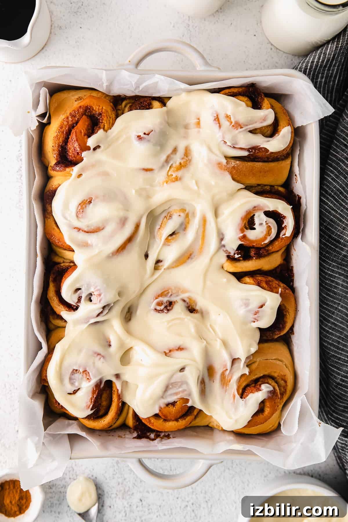 maple cinnamon rolls with a cream cheese frosting in a baking dish