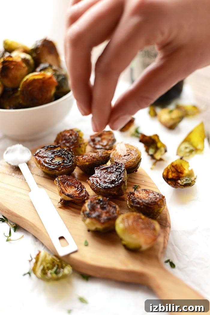 Roasted Brussels Sprouts with Balsamic Glaze 2 roasted brussel sprouts being sprinkled with sea salt