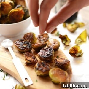 Roasted Brussels Sprouts with Balsamic Glaze 6 Roasted brussel sprouts on a wooden cutting board.