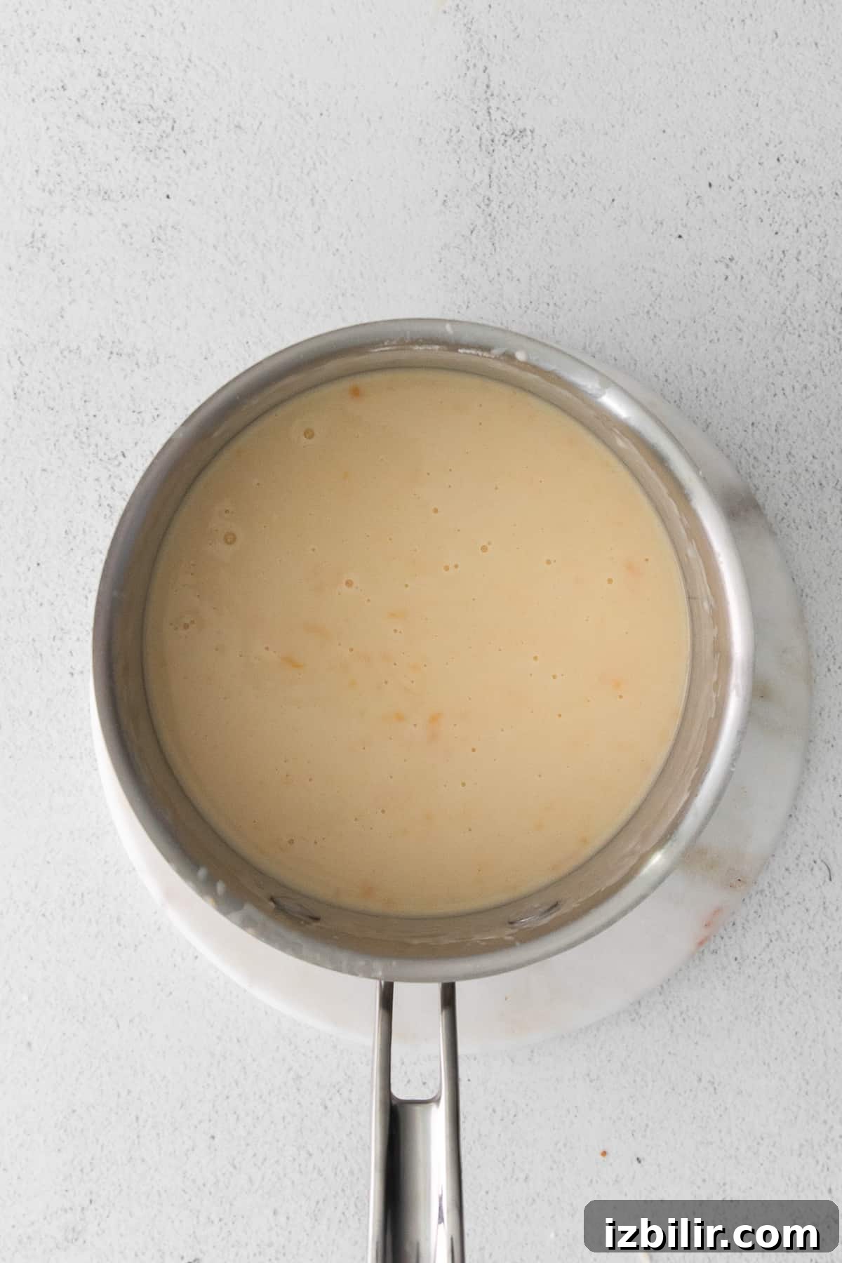 Whisking the cheese sauce roux in pot