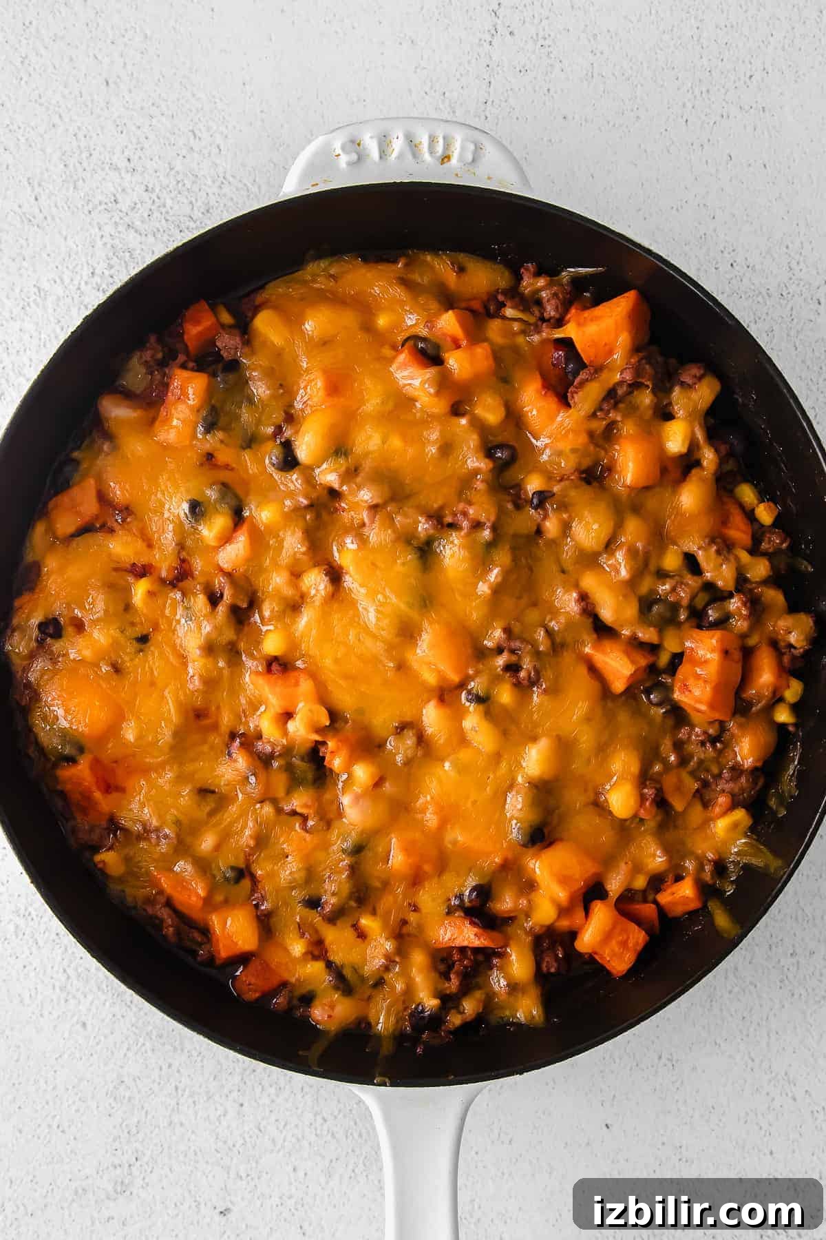 turkey sweet potato enchilada skillet topped with melted shredded cheese
