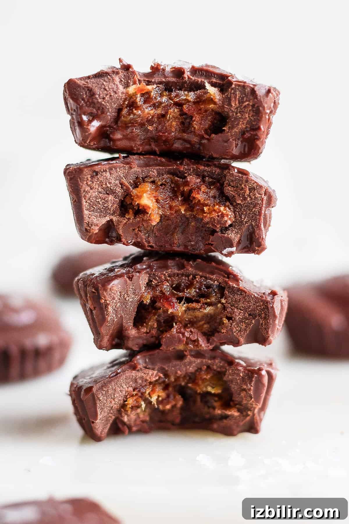 No-Bake Salted Caramel Date Cups Recipe 2 A stack of chocolate squares with one piece removed.