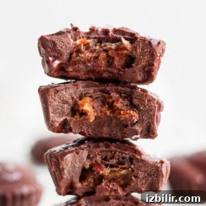 No-Bake Salted Caramel Date Cups Recipe 7 A stack of chocolate peanut butter cups stacked on top of each other.
