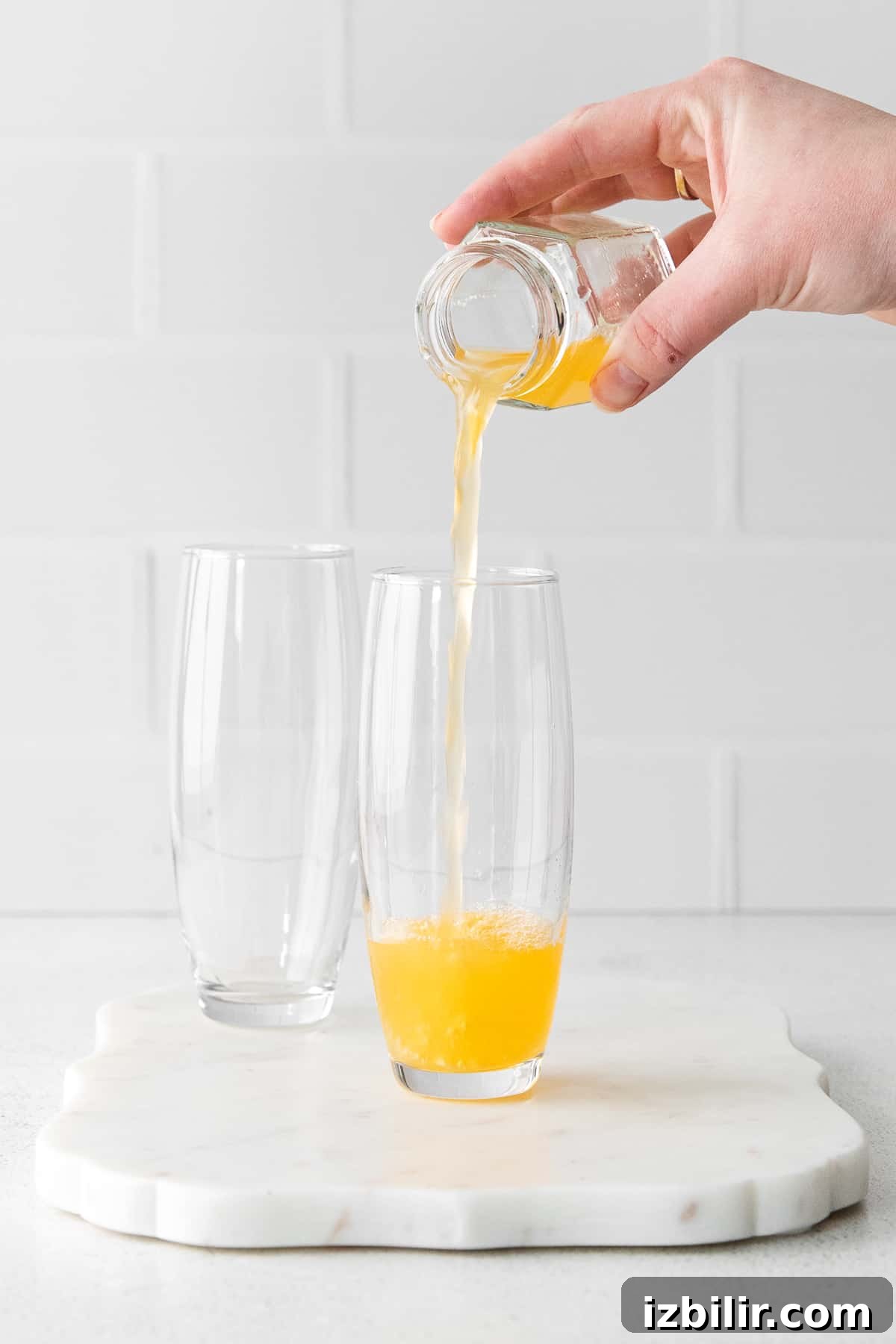 Pouring orange juice orange juice being poured into stemless champagne flutes