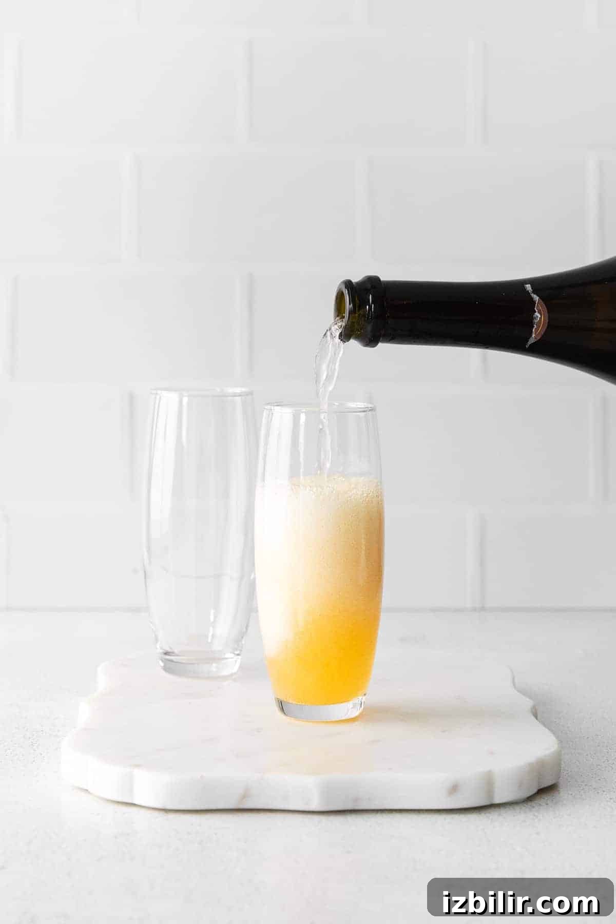 Champagne poured over orange juice champagne being poured into a glass over orange juice