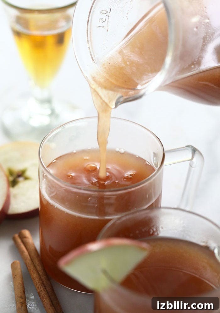 Cranberry Mimosa Recipe and New Year's Cocktails 6 spiked apple cider being poured in a mug
