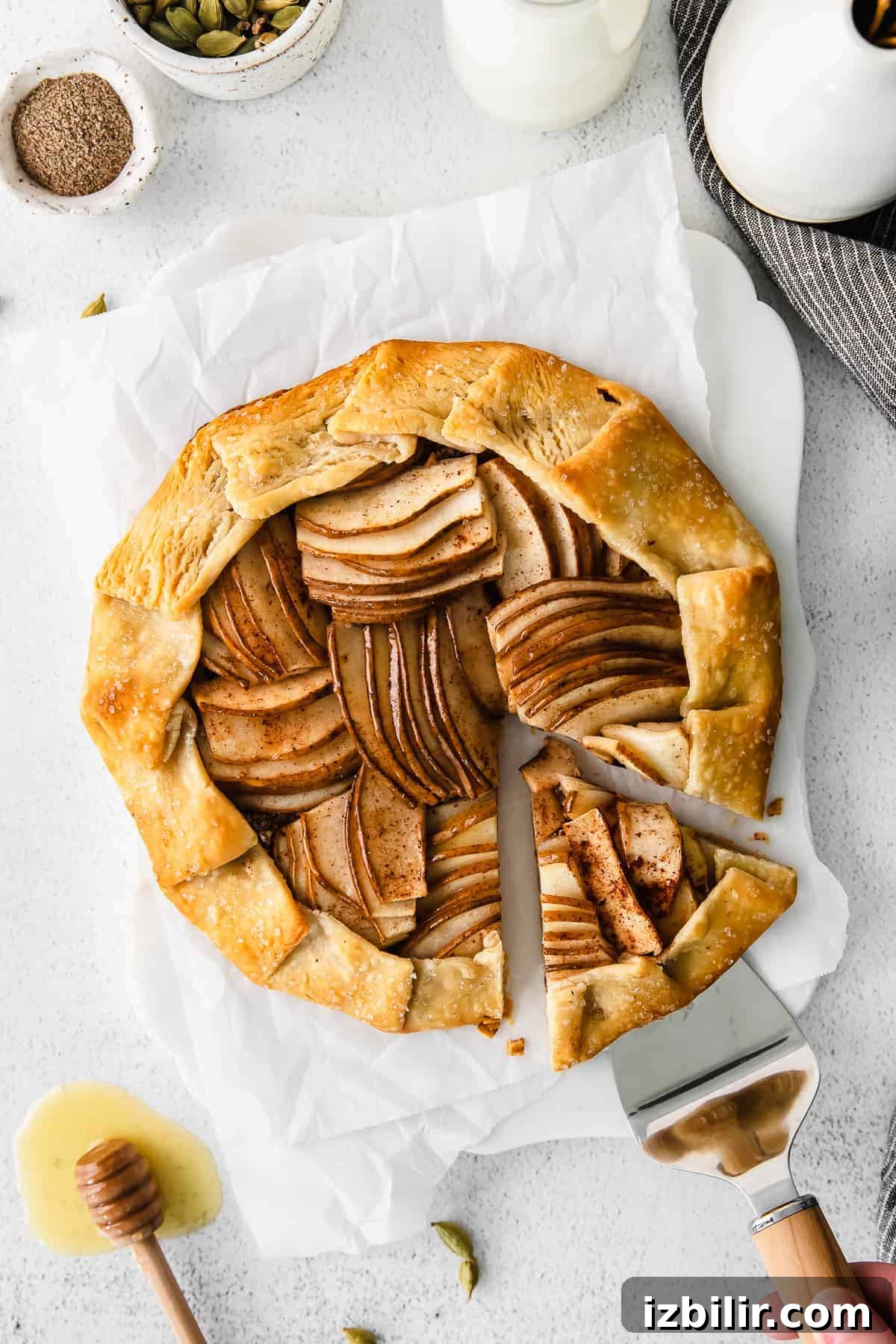 Rustic Honey Pear Galette Recipe 8 Removing a slice of a pear galette with a spatula.