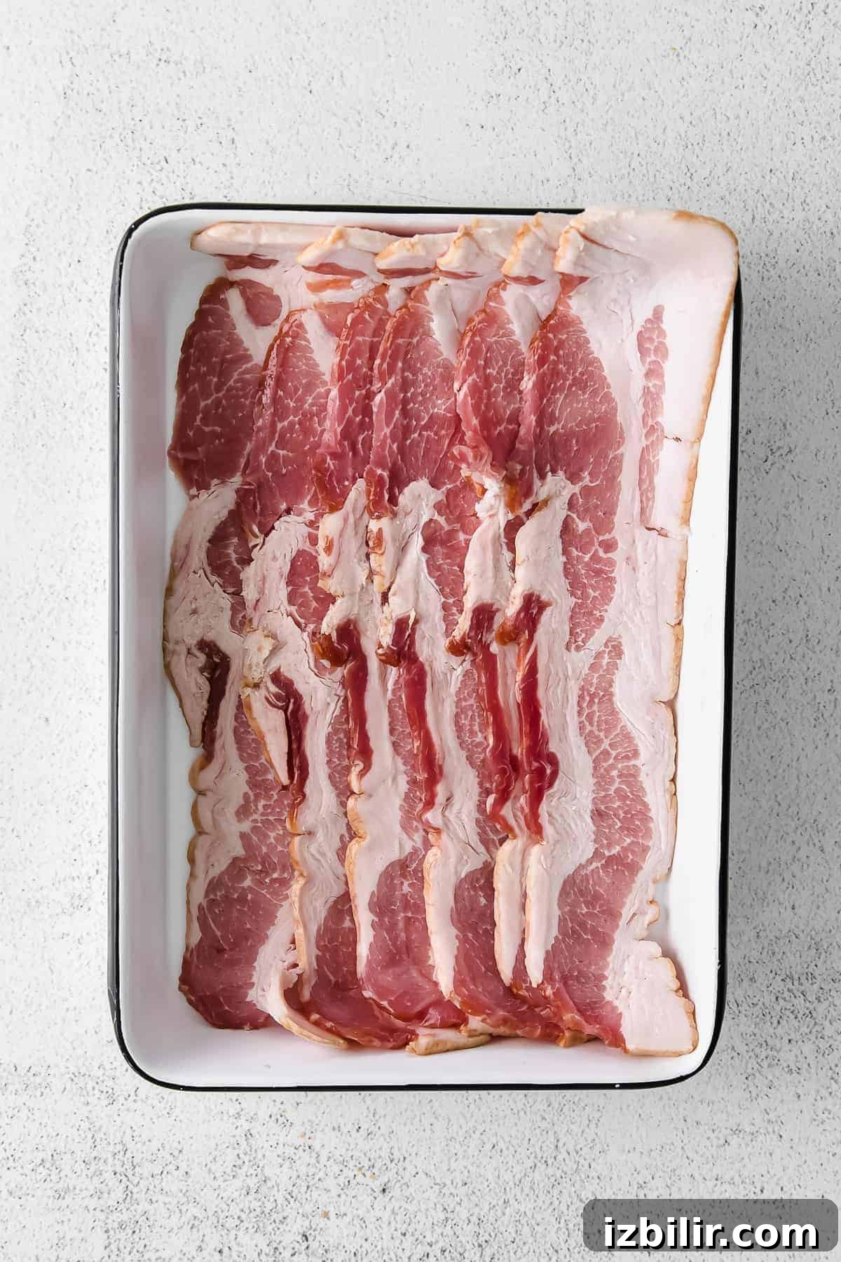 Uncooked bacon ready for the pan uncooked bacon in dish