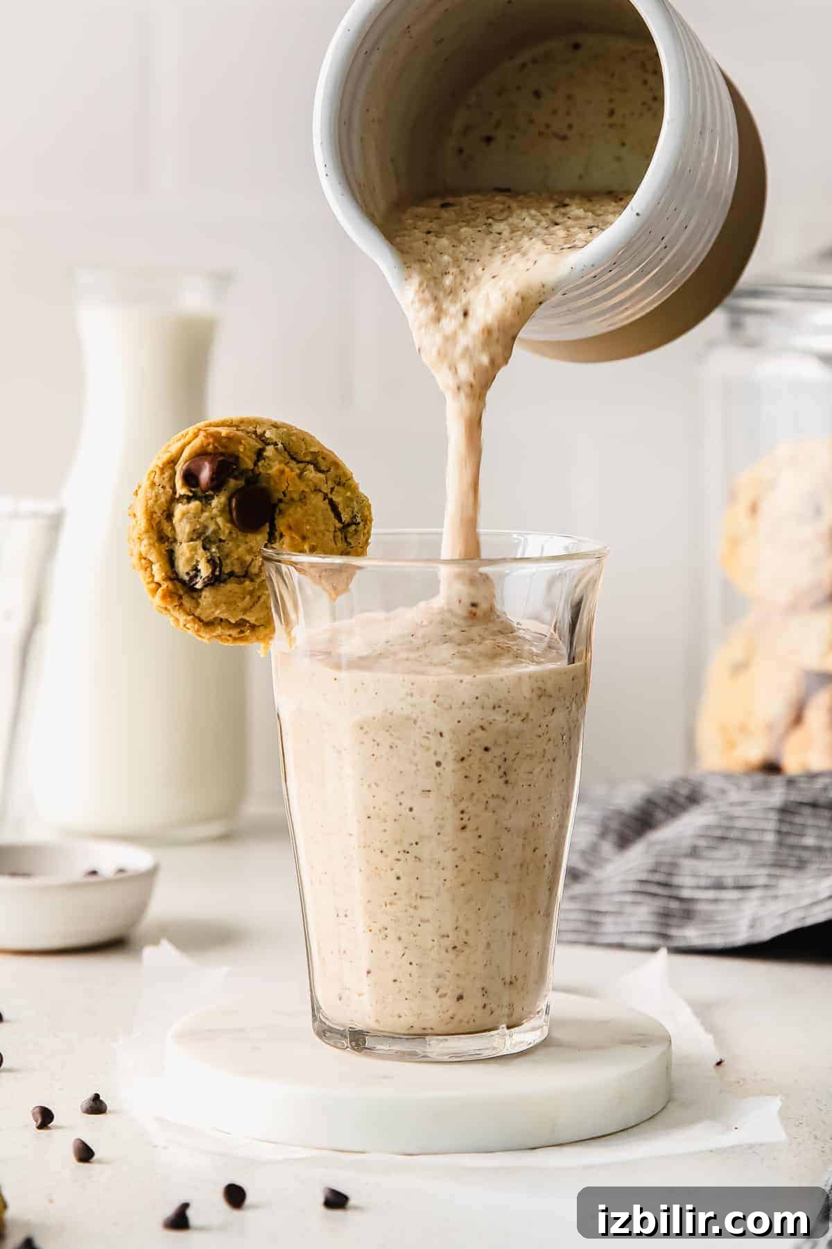 Pouring a cookie dough smoothie into a glass. 