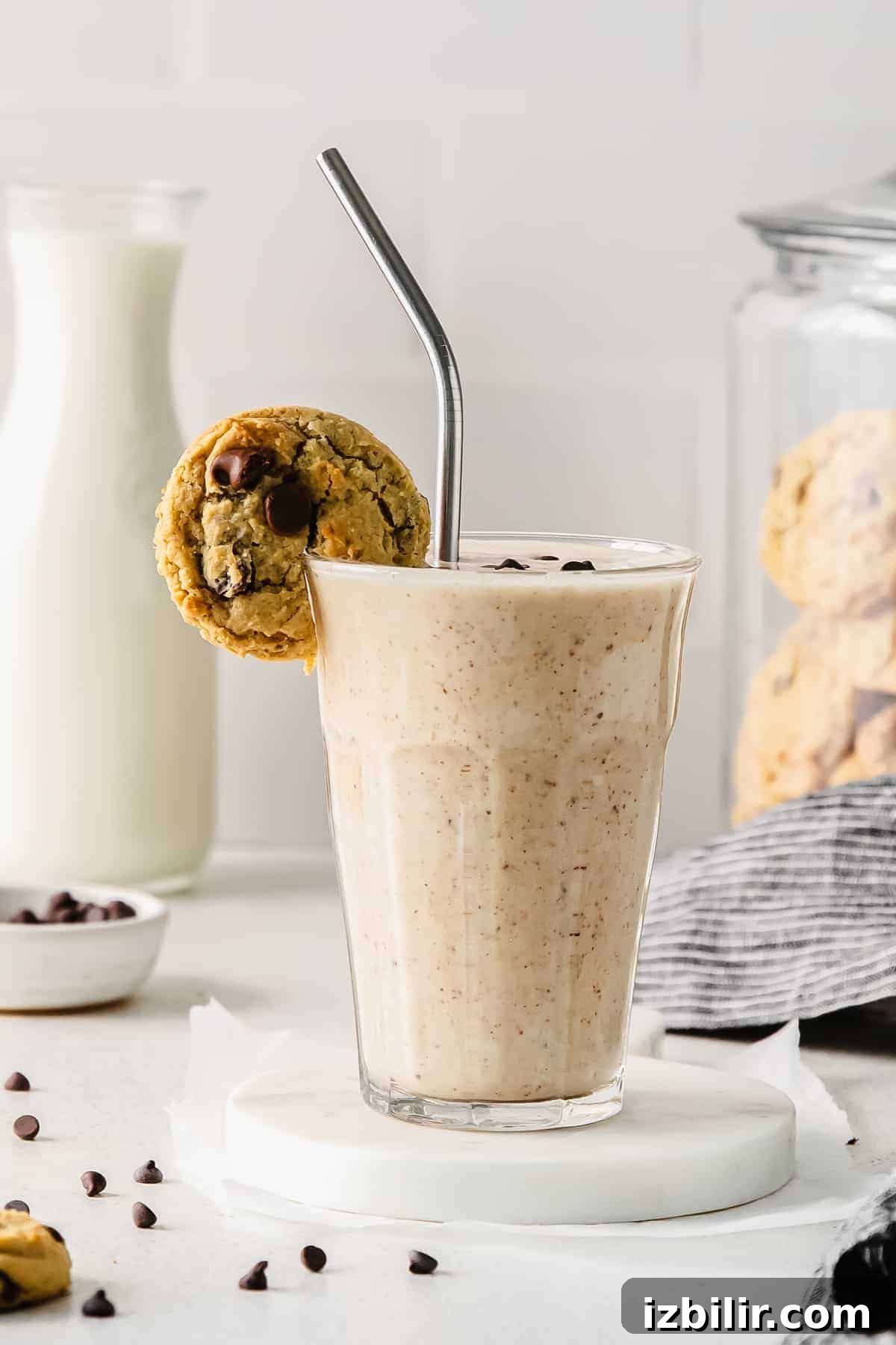 Cookie dough smoothie with a cookie on the rim of a glass. 