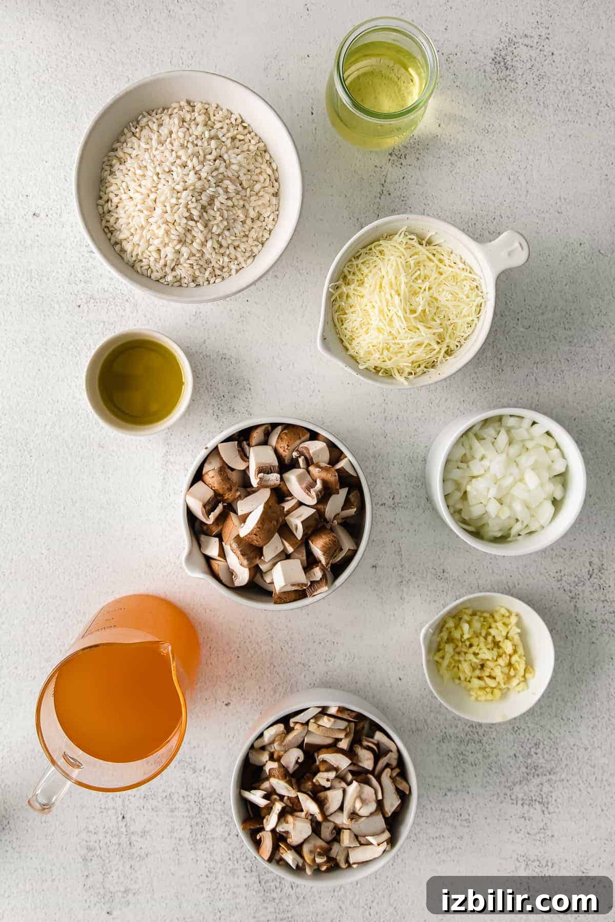 Arborio rice, white onion, parmesan, olive oil, and mushrooms in small bowls.