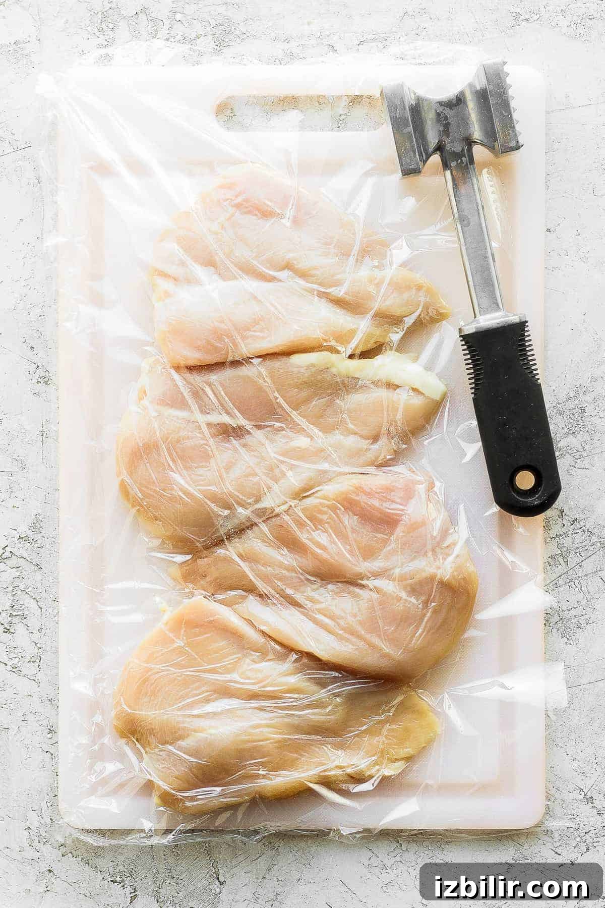 Prepare chicken breasts by pounding to even thickness raw chicken breasts on a cutting board with a meat tenderizer