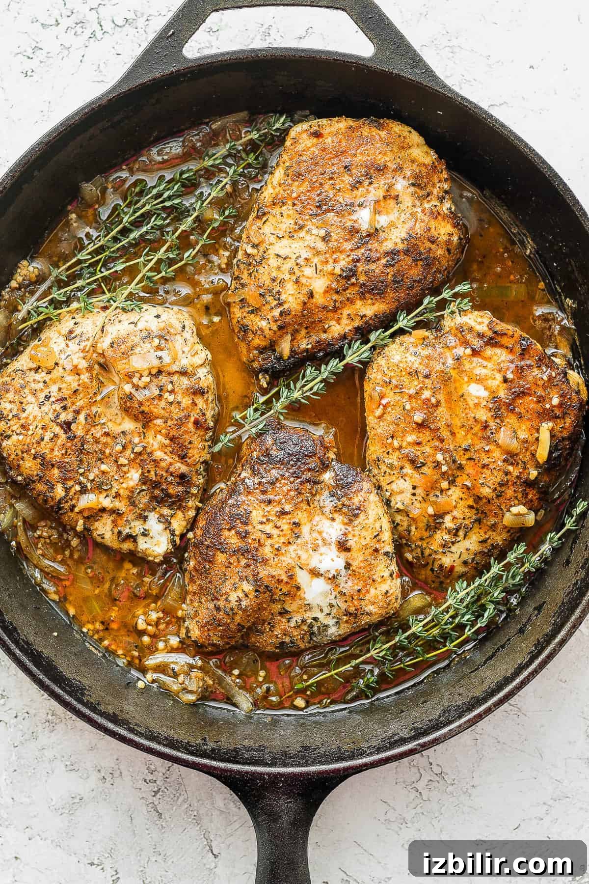 Finished garlic butter chicken with thyme garlic butter chicken in a cast iron skillet with fresh thyme