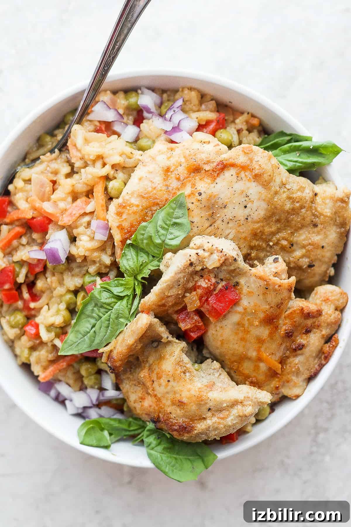 This one-pot curry chicken and rice is a twist on a classic and incorporates tons of veggies and a delicious sauce made with Thai green curry paste, fresh ginger, and coconut milk. chicken thighs on plate