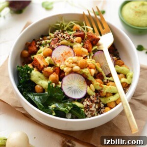 A buddha bowl recipe featuring quinoa and kale salad with a gold fork.