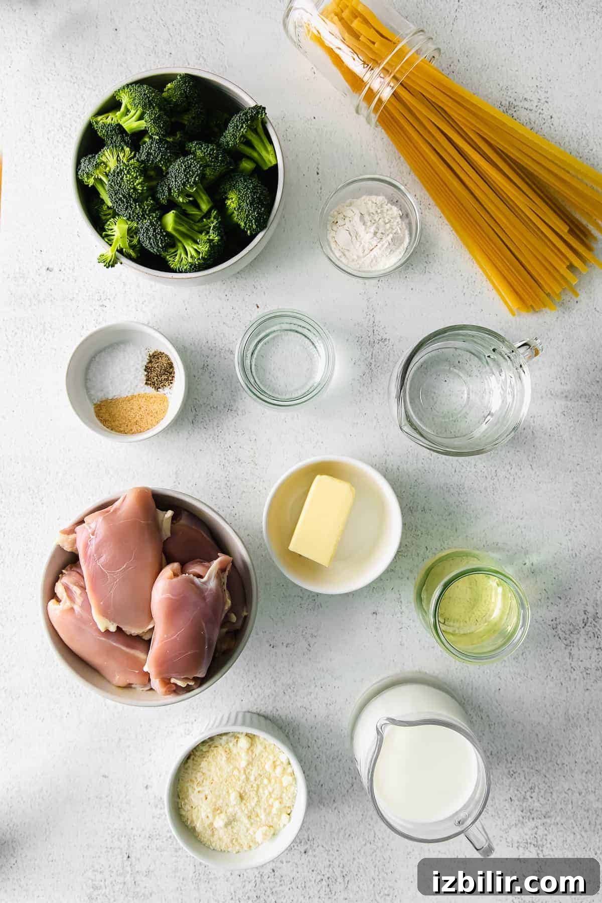 Chicken thighs, butter parmesan, garlic, milk, and few other ingredients in bowls. 