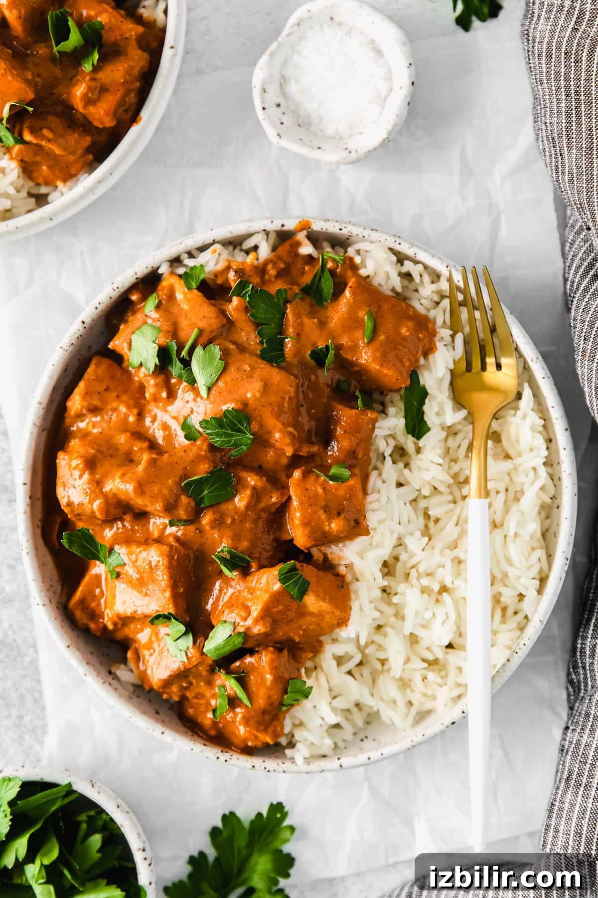 Butter chicken in a bowl served over rice.