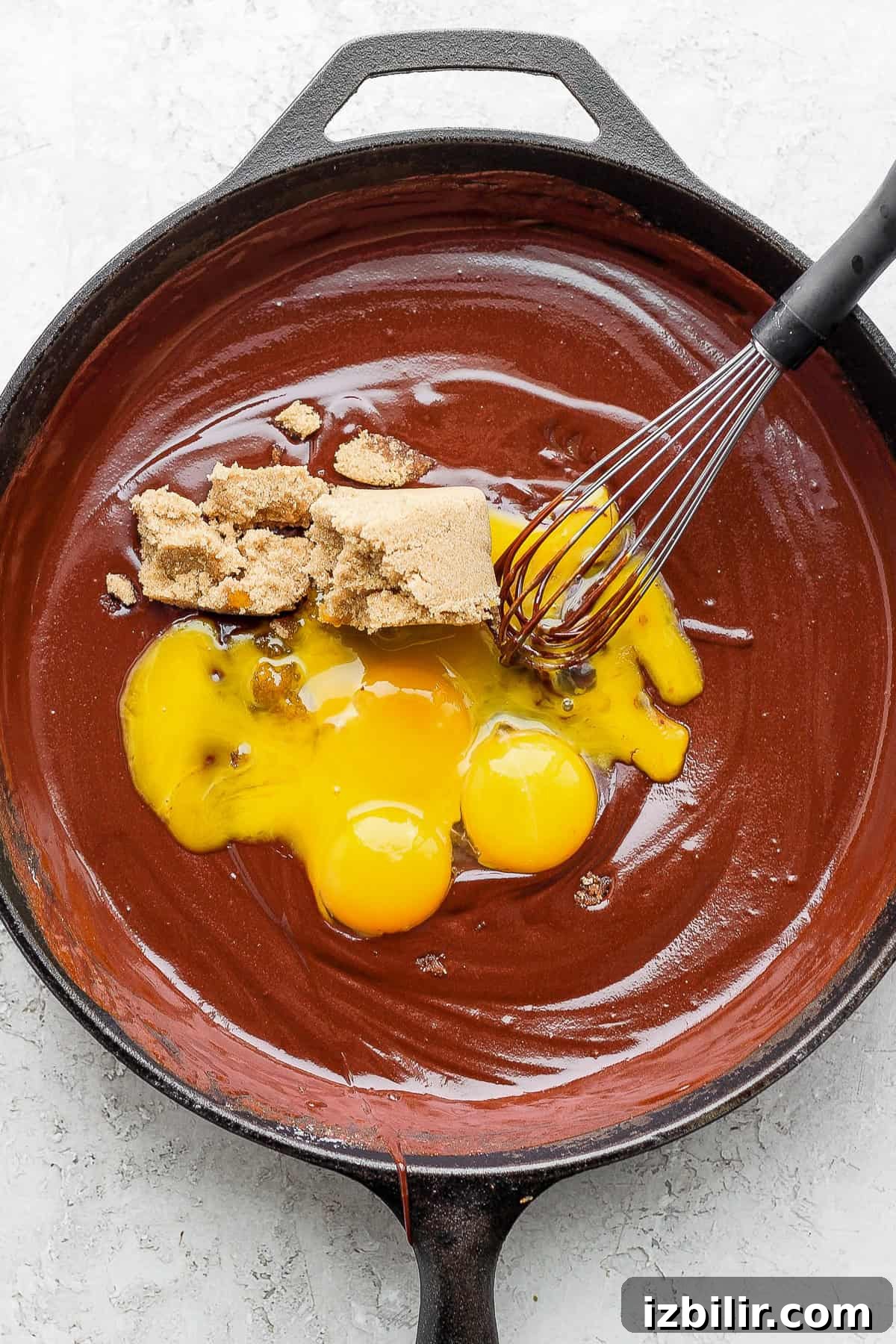 Egg yolks and brown sugar added to the batter egg yolks and brown sugar being added to the flourless chocolate skillet cake batter