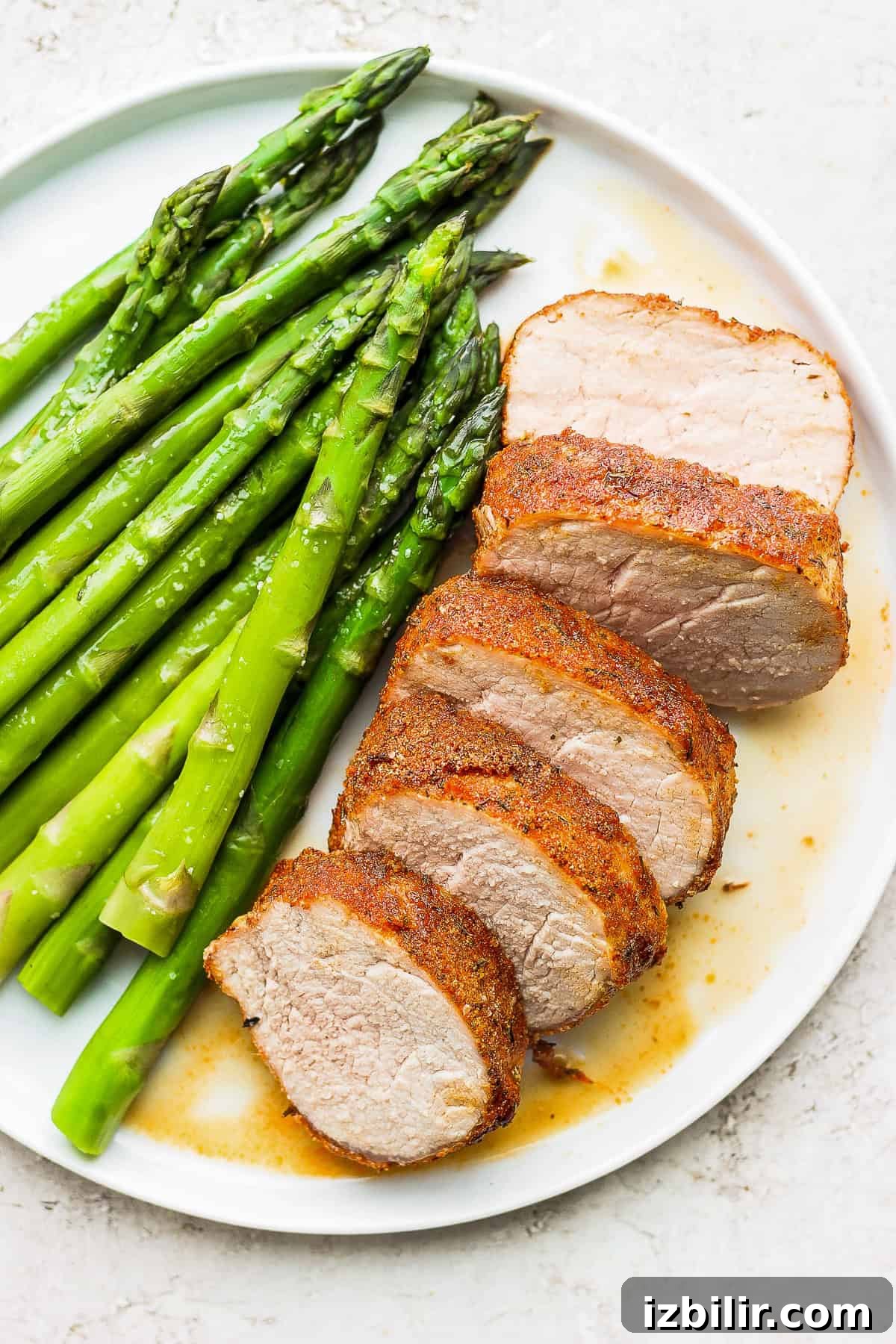 Crispy Air Fryer Pork Tenderloin with Garlic Herb Rub 2 air fryer pork tenderloin on a plate with asparagus