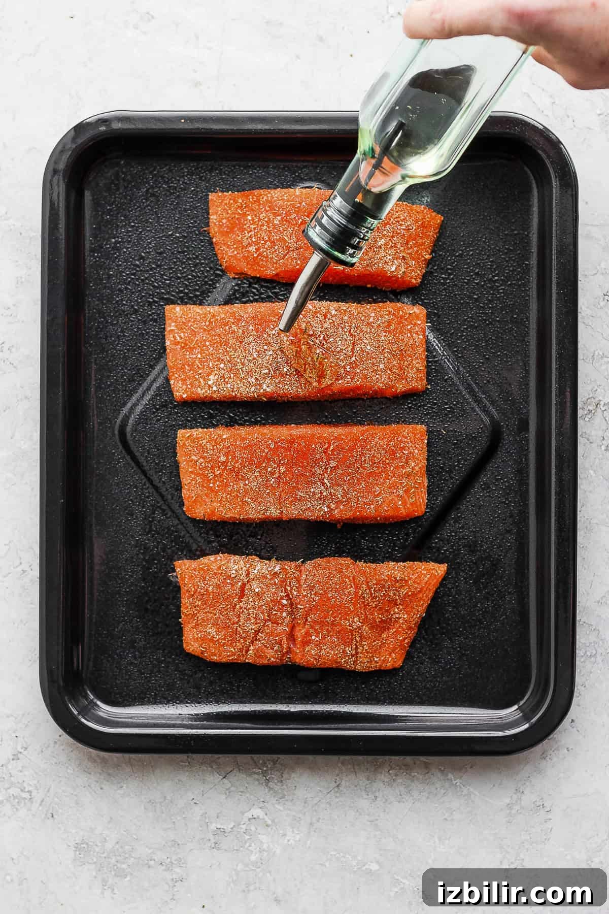 Drizzle with olive oil for extra crispiness Drizzling salmon with olive oil before cooking