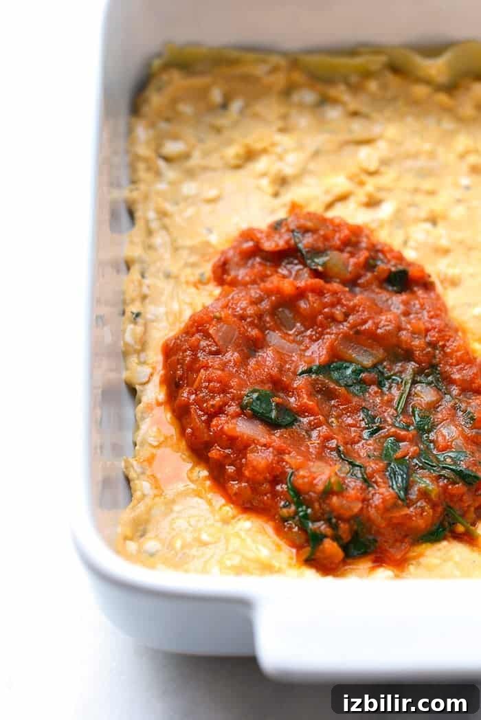 Spreading sauce on lasagna noodles sauce being spread on lasagna noodles for sweet potato lasagna