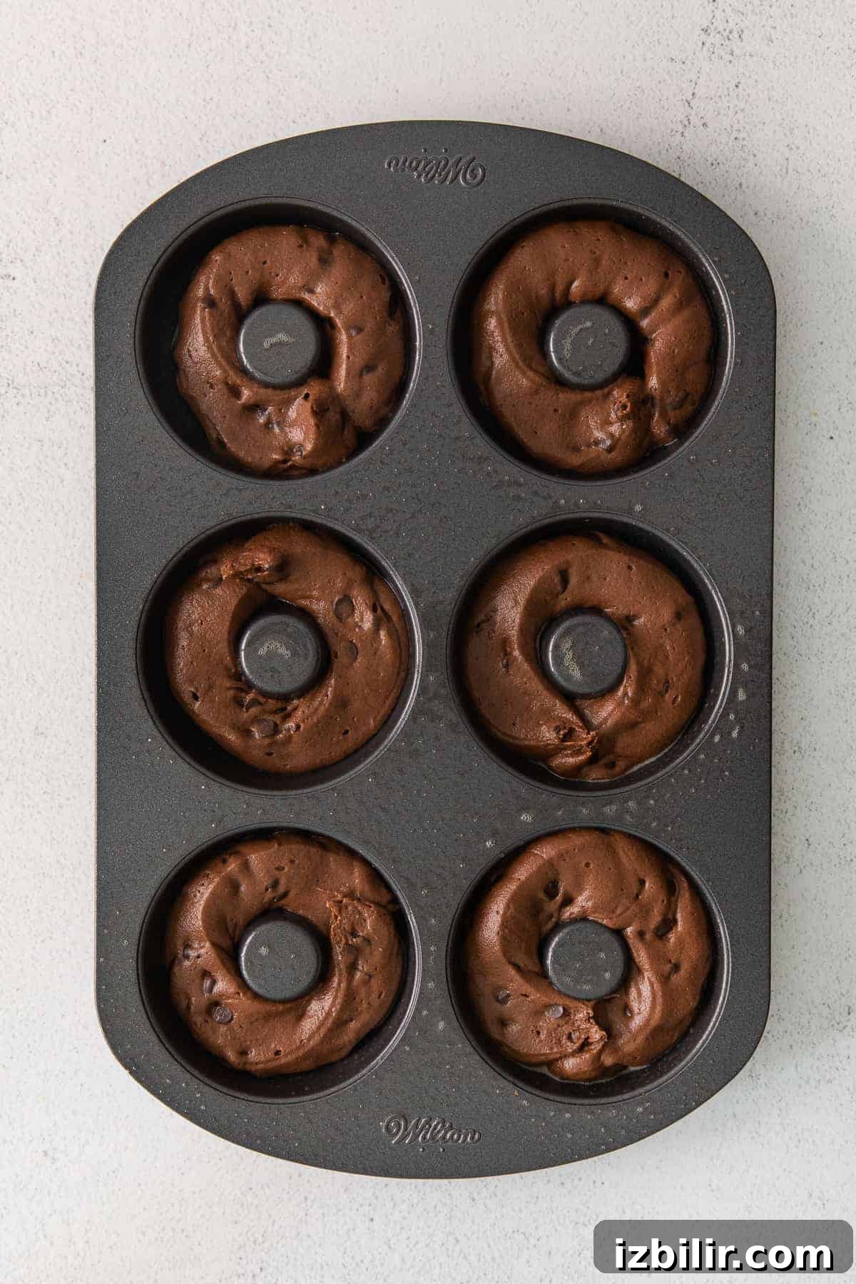 Batter piped into donut pan batter piped into donut mold